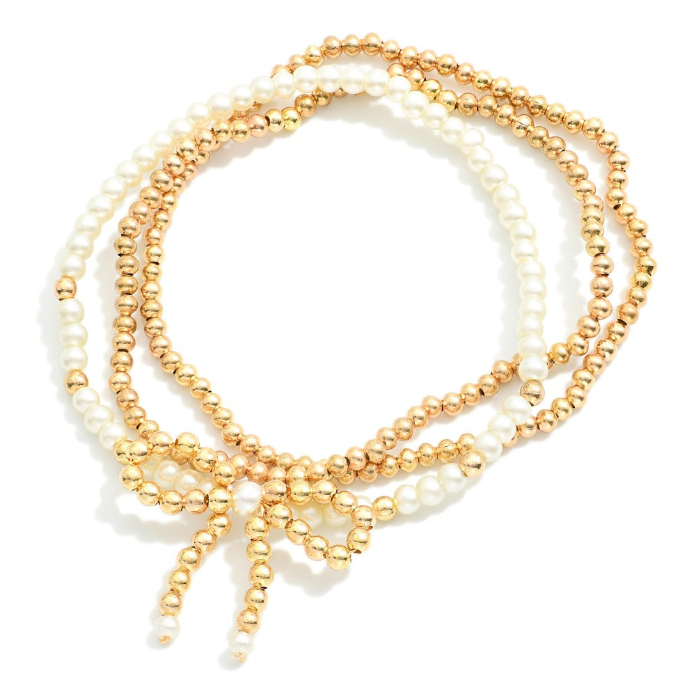 Set of Three Metal Tone and Pearl Beaded Stretch Bracelets With Metal Tone Beaded Bow Focal