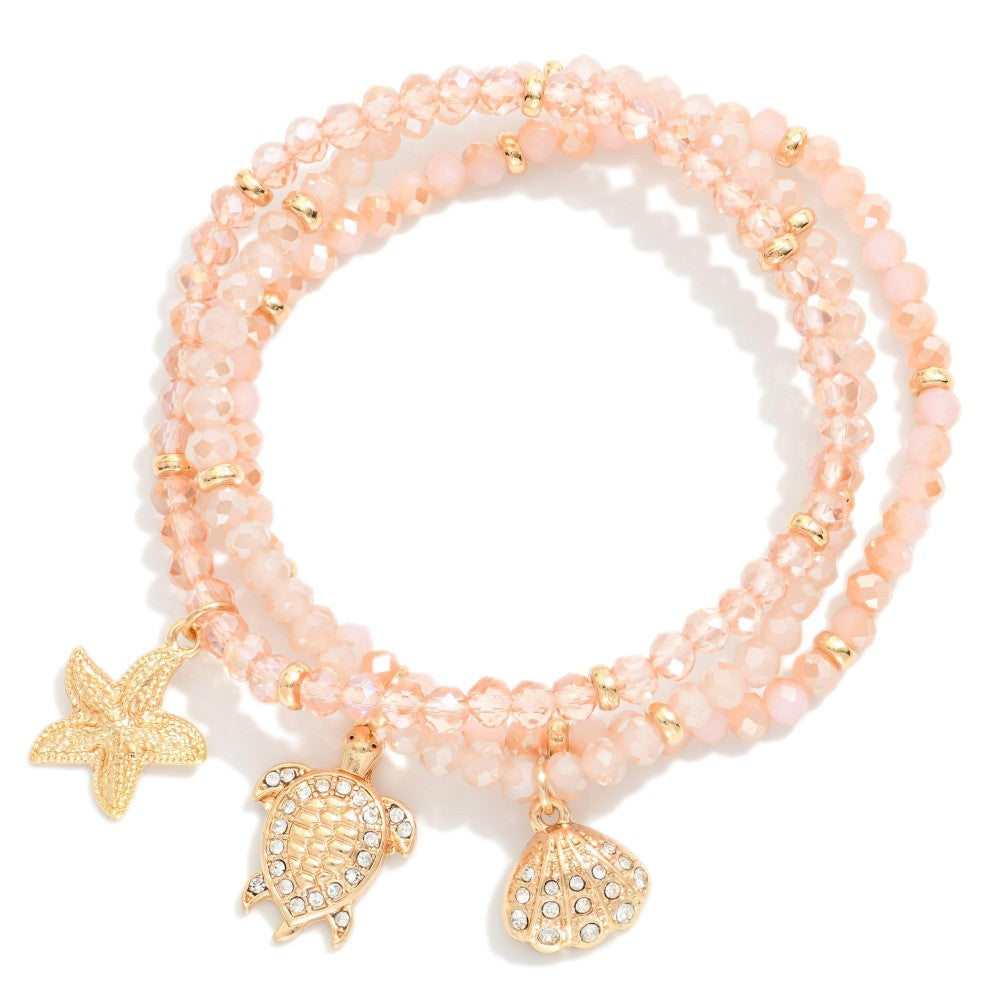 Set Of Three Faceted Bead Stretch Bracelets Featuring Metal Tones, & Beach Charms - Pink