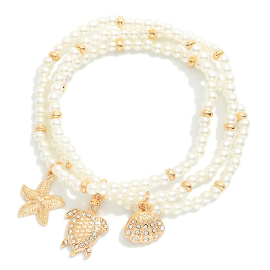 Set Of Three Faceted Bead Stretch Bracelets Featuring Metal Tones, & Beach Charms - Cream