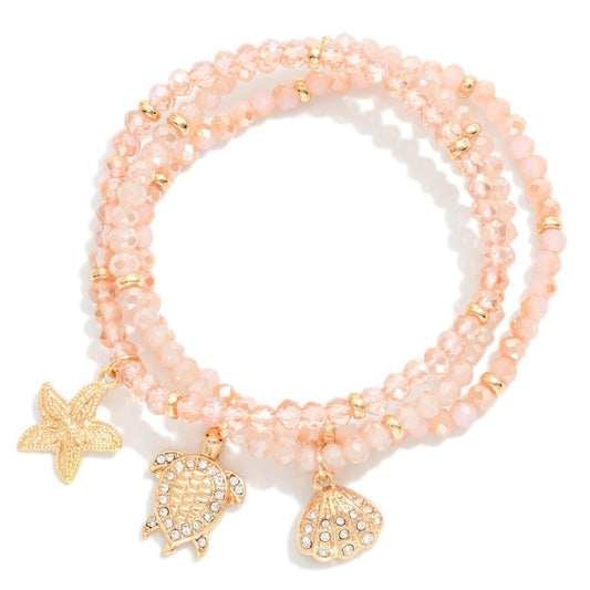 Set Of Three Faceted Bead Stretch Bracelets Featuring Metal Tones, & Beach Charms - Pink