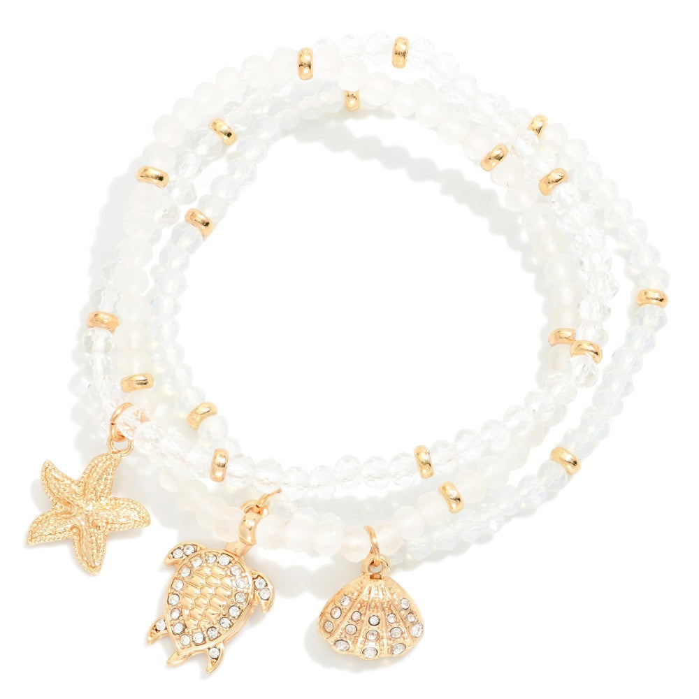 Set Of Three Faceted Bead Stretch Bracelets Featuring Metal Tones, & Beach Charms - White